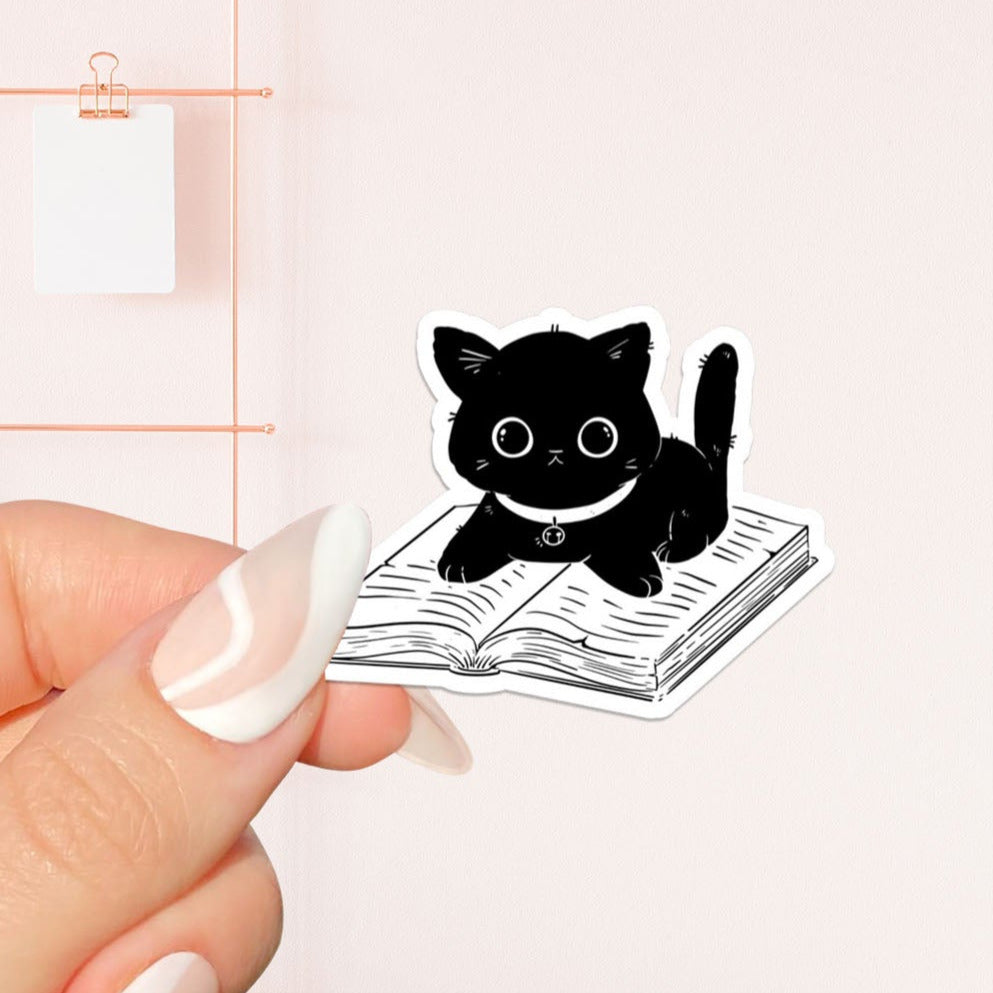 Cat sitting on a book Sticker